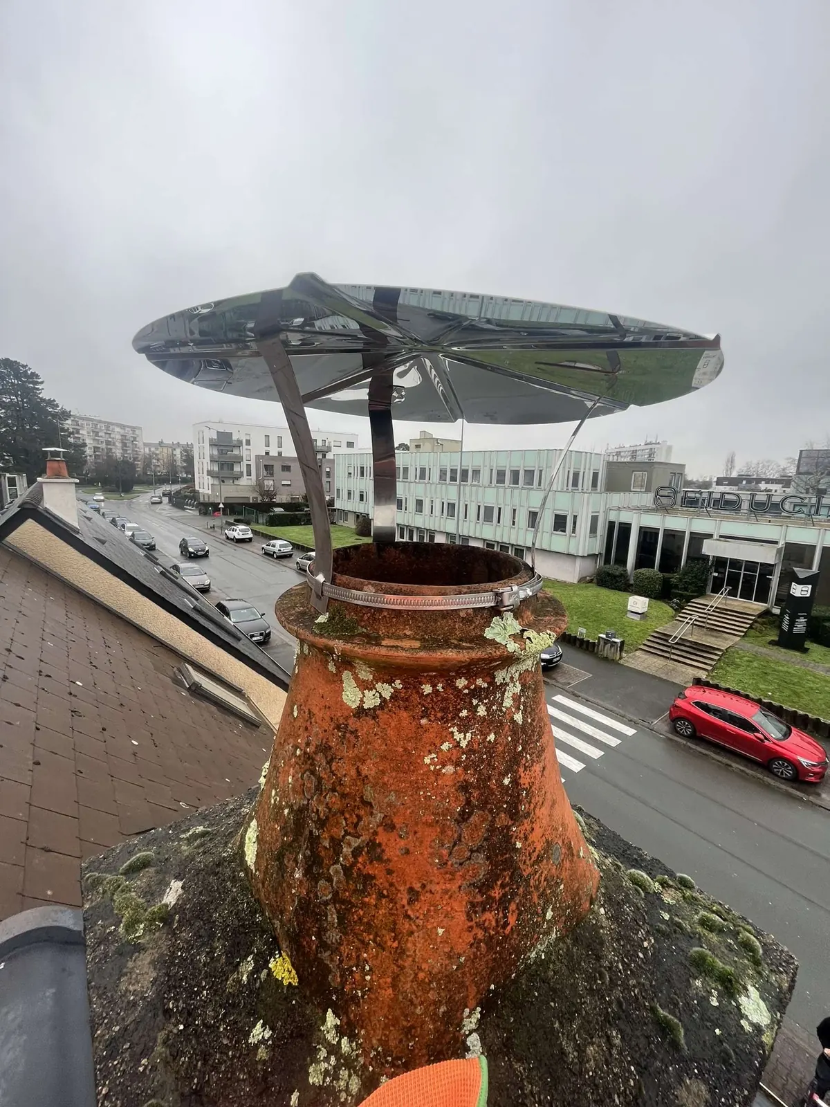 Chapeau de pluie posé sur un conduit à Angers après une infiltration